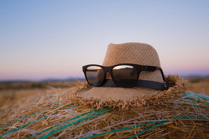 black framed wayfarer-style sunglasses on brown hat