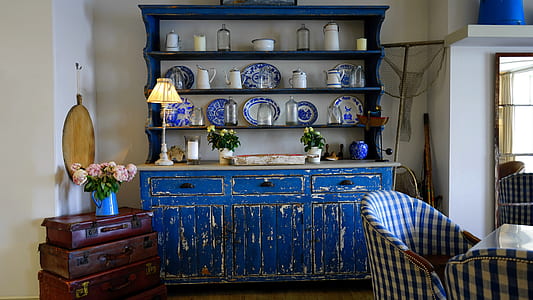blue wooden sideboard with rack near chairs