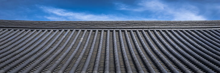 low-angle photography of roof under white clouds and blue sky