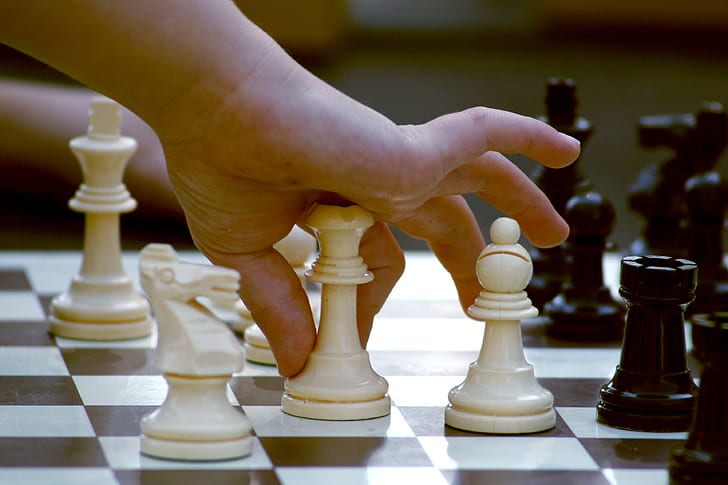 person holding chess piece