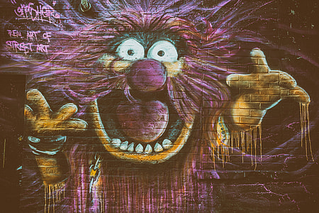 Street art depicting The Animal character from The Muppets captured on a brick wall
