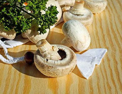 white mushrooms on brown wooden surface