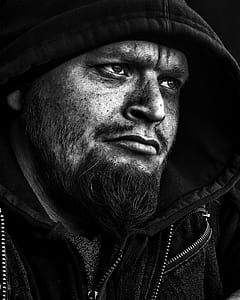 black and white photo of man with hooded jacket