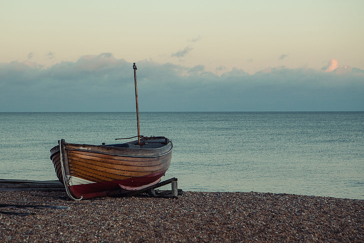 A boat sits on the shore on a tranquil sunset in Southern England, image captured with a Canon 5D