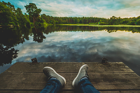Man with his feet in shot relaxing at a lake