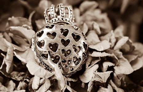 grayscale photography of heart with crown pendant