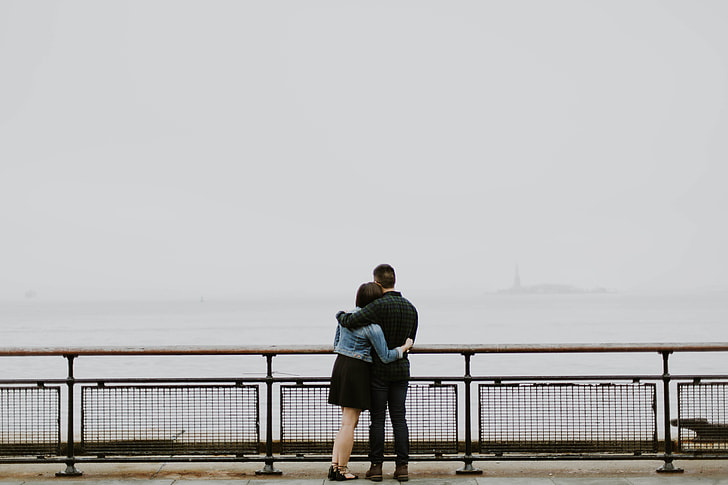 man and woman hugging near on black frame