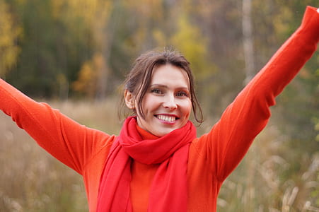 photo of woman wearing orange sweater and red scarf