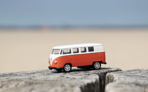 shallow focus photography of white and red Volkswagen Samba die-cast toy car