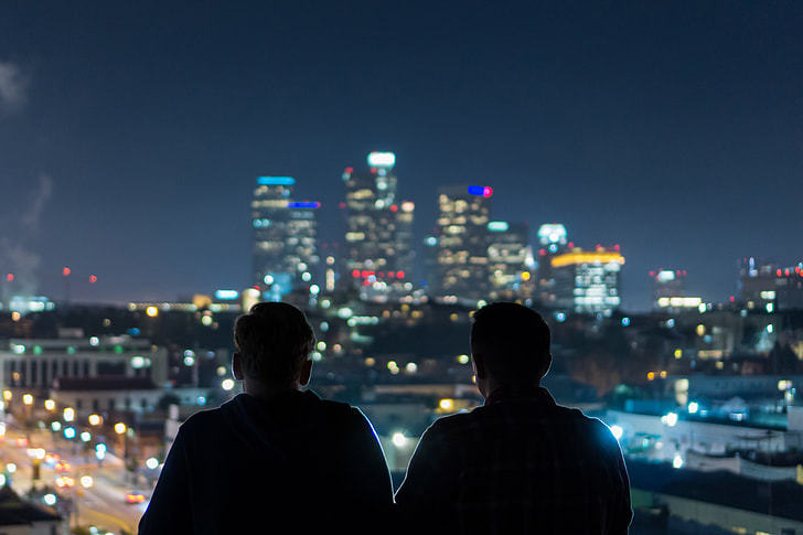 Two men viewing the city at night