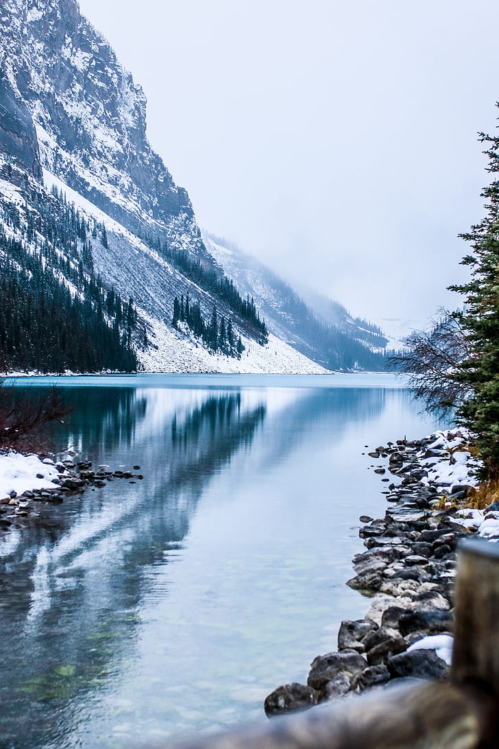 calm body of water near snow filled mountains digital wallpaper
