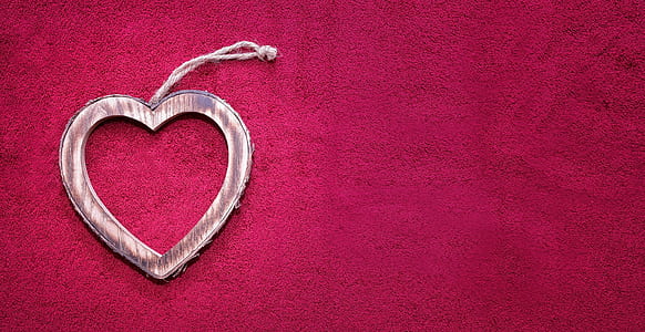 pink heart hanging decor on red textile