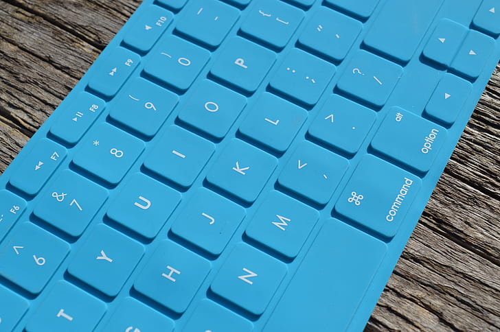 blue Apple keyboard on brown desk
