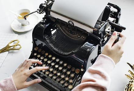 woman holding black typewriter