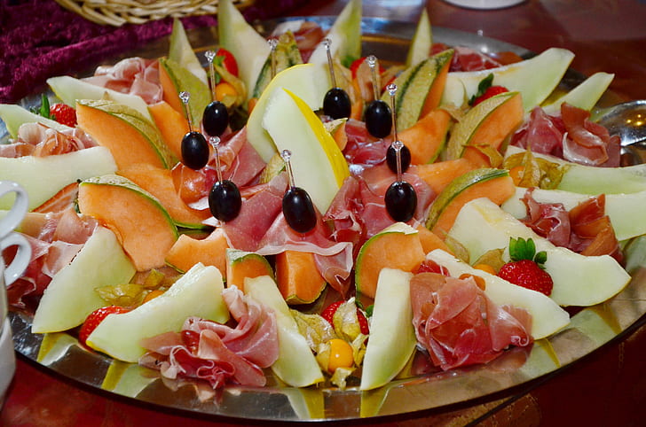 assorted sliced fruits and meat on silver platter