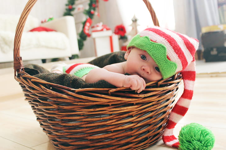 infant lying on brown basket