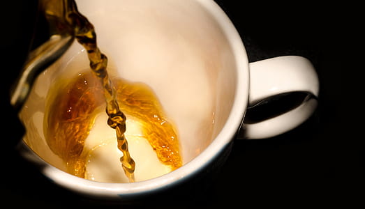 yellow liquid pour on white ceramic mug