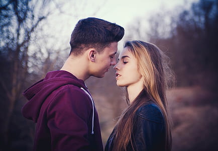 selective focus photo of man and woman about to kiss