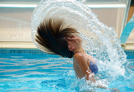 woman wearing blue bikini tops in swimming pool during daytime