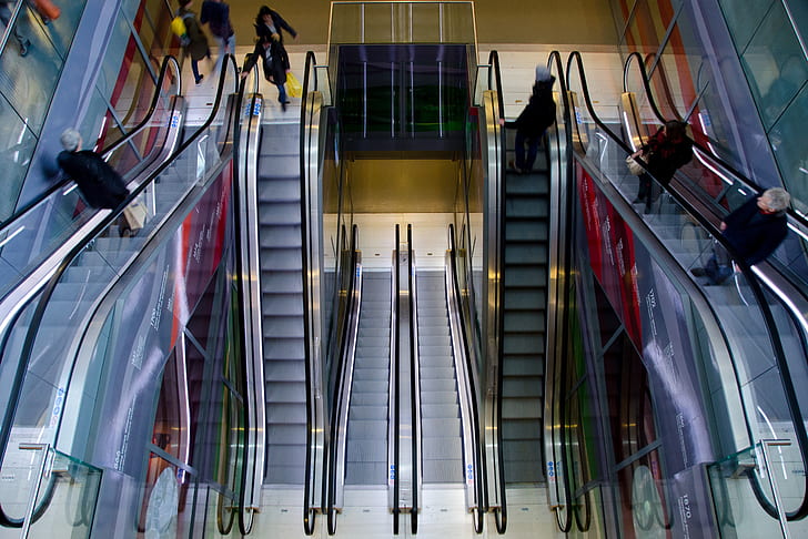 people riding on a escalator inside a buildings
