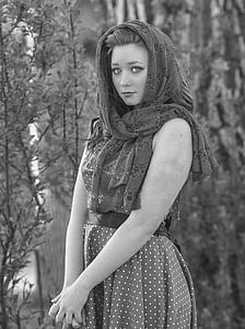 grayscale photo of woman in floral scarf and polka-dot sleeveless dress