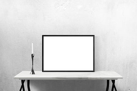 rectangular white board with black wooden frame on top of white wooden console table
