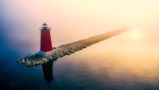 red and white lighthouse during sunset