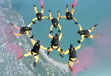 group of people parachuting over city near water