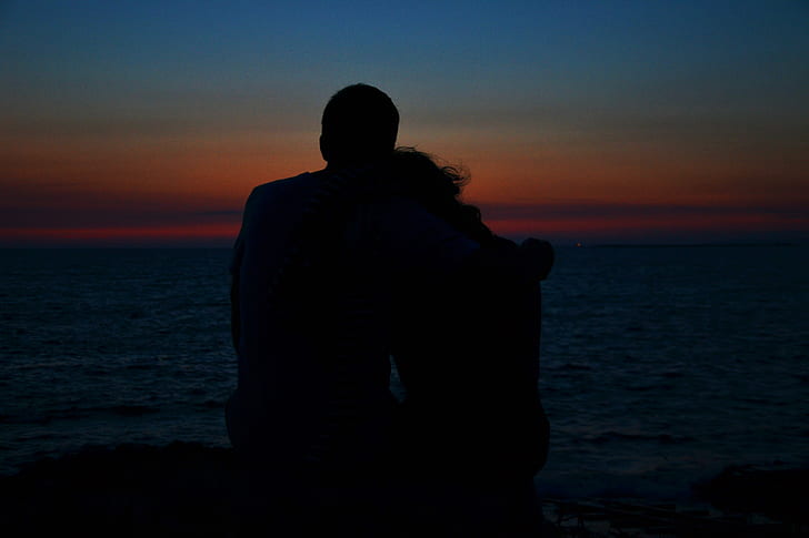 silhouette of man and woman during golden hour