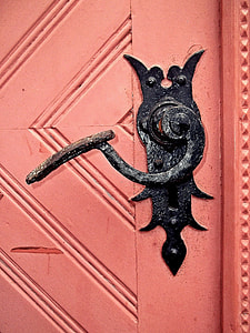 pink wooden door with black knob