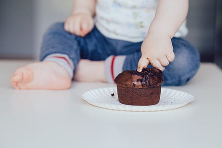 toddler putting finger in chocolate muffin