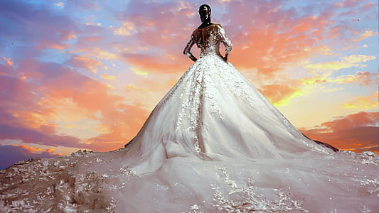 woman with white ball water gown under yellow sky during daytime time lapse photo