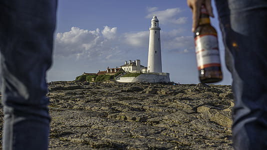 white lighthouse under cloudy blue sky during daytime