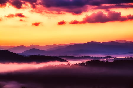 silhouette of mountain range with fog