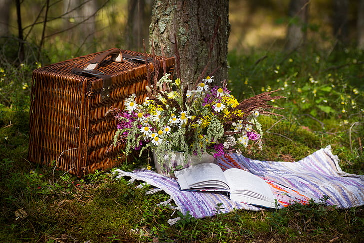 brown picnic basket and flower arrangement