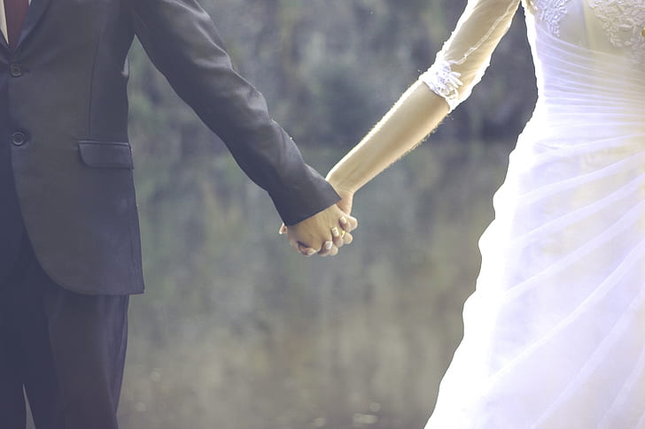 bride and groom holding hands during daytime