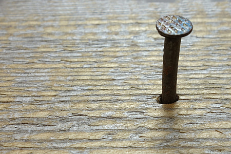 closeup photography of brown wooden surface with gray nail
