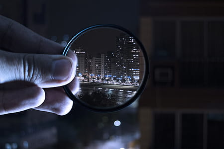 Person Holding Magnifying Glass