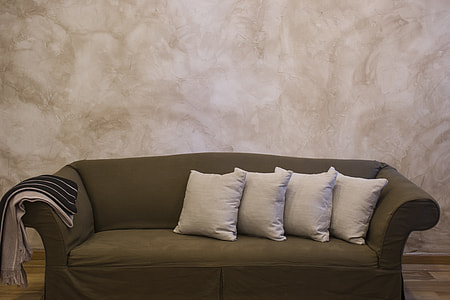 empty gray fabric sofa and four white throw pillows