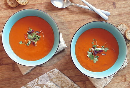 two bowls of tomato garnished soup