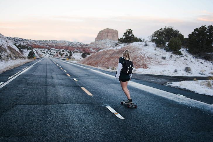woman in black riding a skateboard