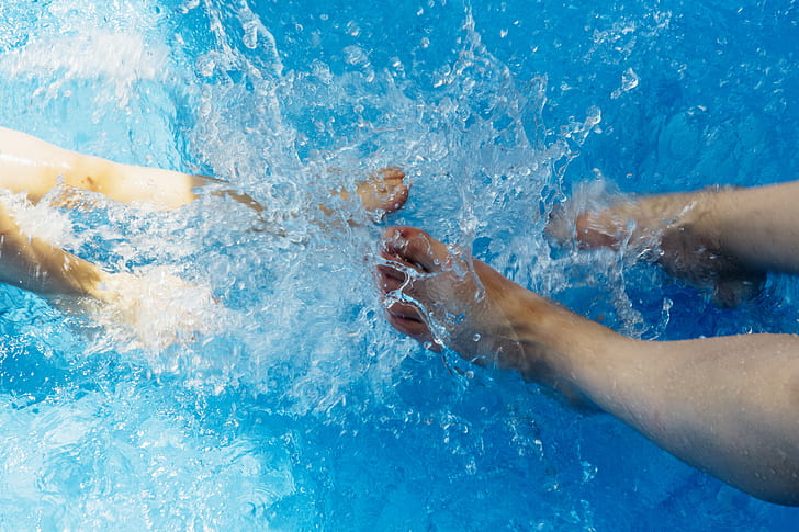 two pairs of feet splashing water