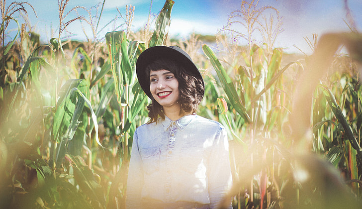 woman standing on corn field during daytime