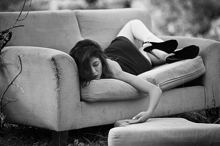 woman in black dress lying on sofa