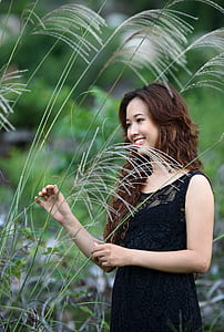woman wearing black lace sleeveless dress beside plants