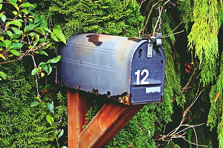 blue metal mailbox on brown wooden post photography