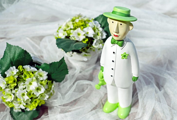 man wearing white suit figurine on white mesh cloth