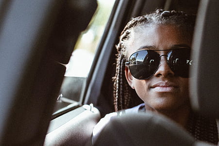 photography of braided hair woman wearing black aviator sunglasses with silver-colored frames