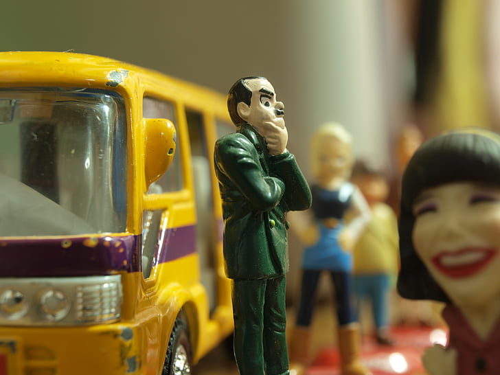 shallow focus photography of man in green suit coat plastic toy