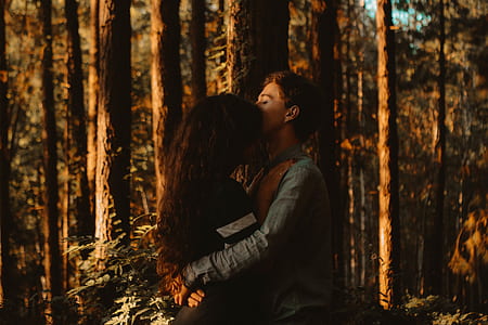 man and woman hugging in the forest